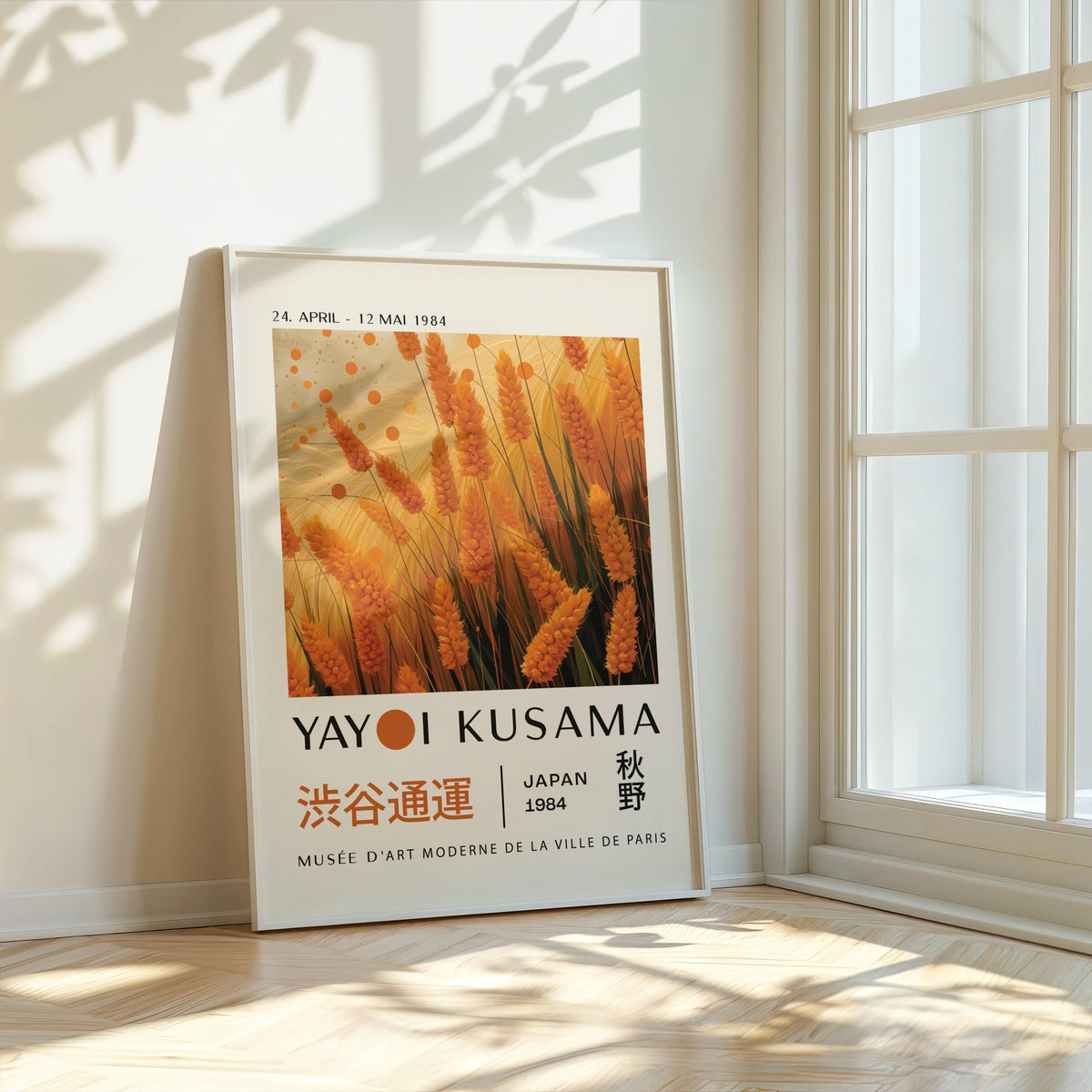 Print leaning on a floor showing autumnal wall art with orange wheat and abstract dots by a bright window