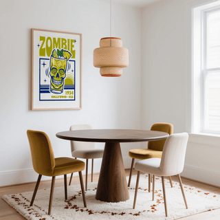 Zombie Cocktail art print with skull cocktail glass in yellow and blue above a dining table with mustard and cream chairs