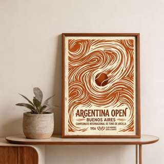 Framed Argentina Open Poster with a vintage tennis ball illustration in brown and cream on a wooden table with a plant