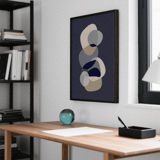 Abstract Modern Art framed print with overlapping beige and grey shapes above a wooden desk with a glass orb