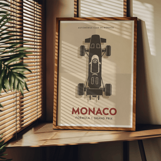 Top-Down Racing Car Poster leaning on a wooden shelf with sunlight and shadows and a plant nearby