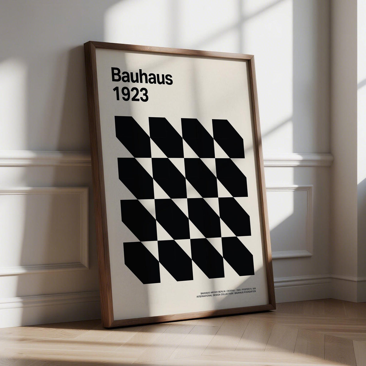 Print leaning on floor with black geometric shapes grid and text Bauhaus 1923 in natural light
