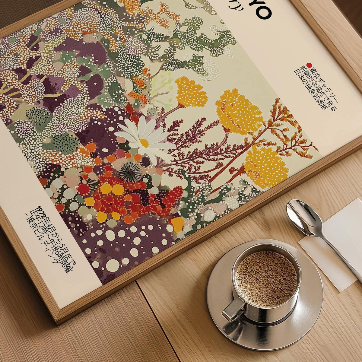 Framed close-up of vintage floral print with yellow and purple abstract flowers beside coffee cup