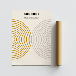 Minimalist wall decor with concentric circles in ochre and grey next to a brown packaging tube