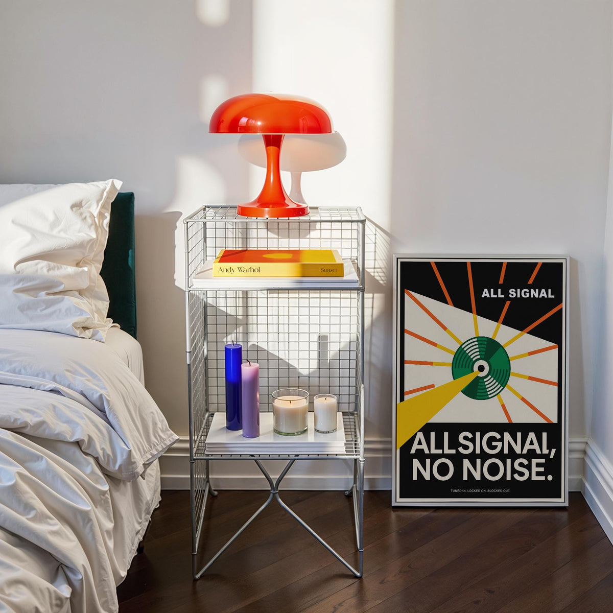 Vinyl Record Poster leaning on the floor next to a metal mesh side table with candles and books