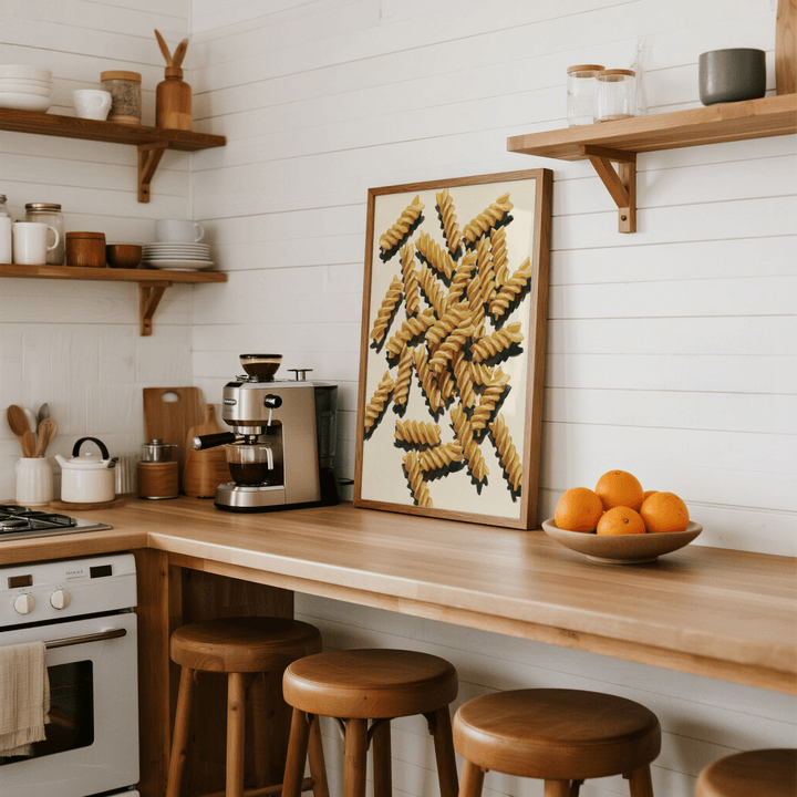 Fusilli Pasta Art print leaning on kitchen countertop with oranges on a wooden bowl nearby
