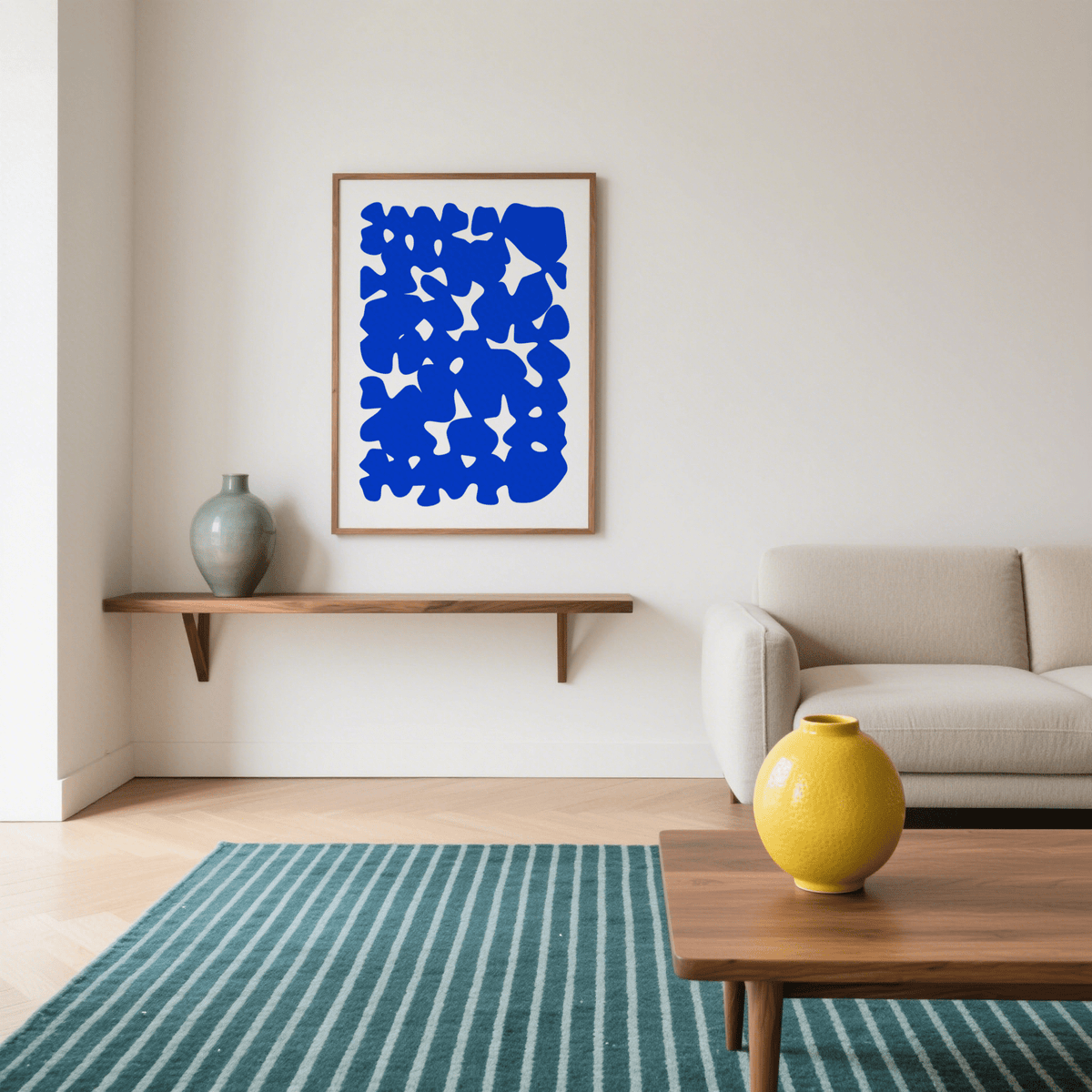 Modern Abstract Art with blue shapes in a wood frame above a shelf with a green vase in a living room