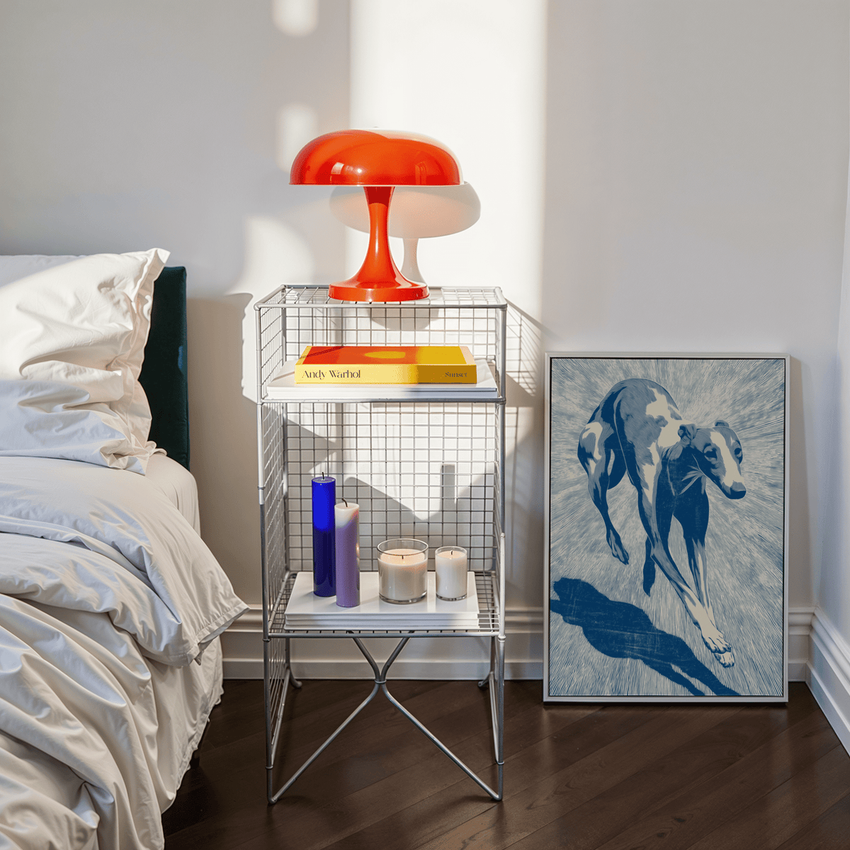 Dog wall art of a running greyhound in blue tones leaning on a wooden floor next to a metal side table with a red lamp