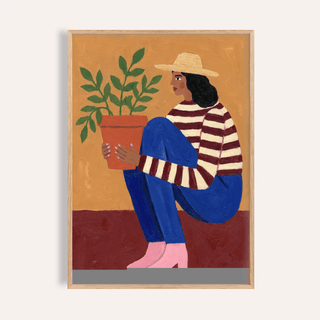 Woman Plant wall art showing a woman in a striped top holding a green leafy plant with a hat
