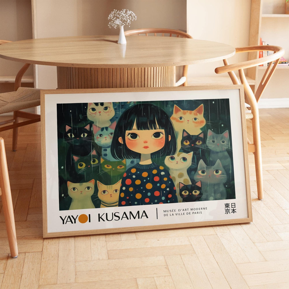 Unique wall art of a girl with cats in dark colours leaning against a round wooden table in a bright room