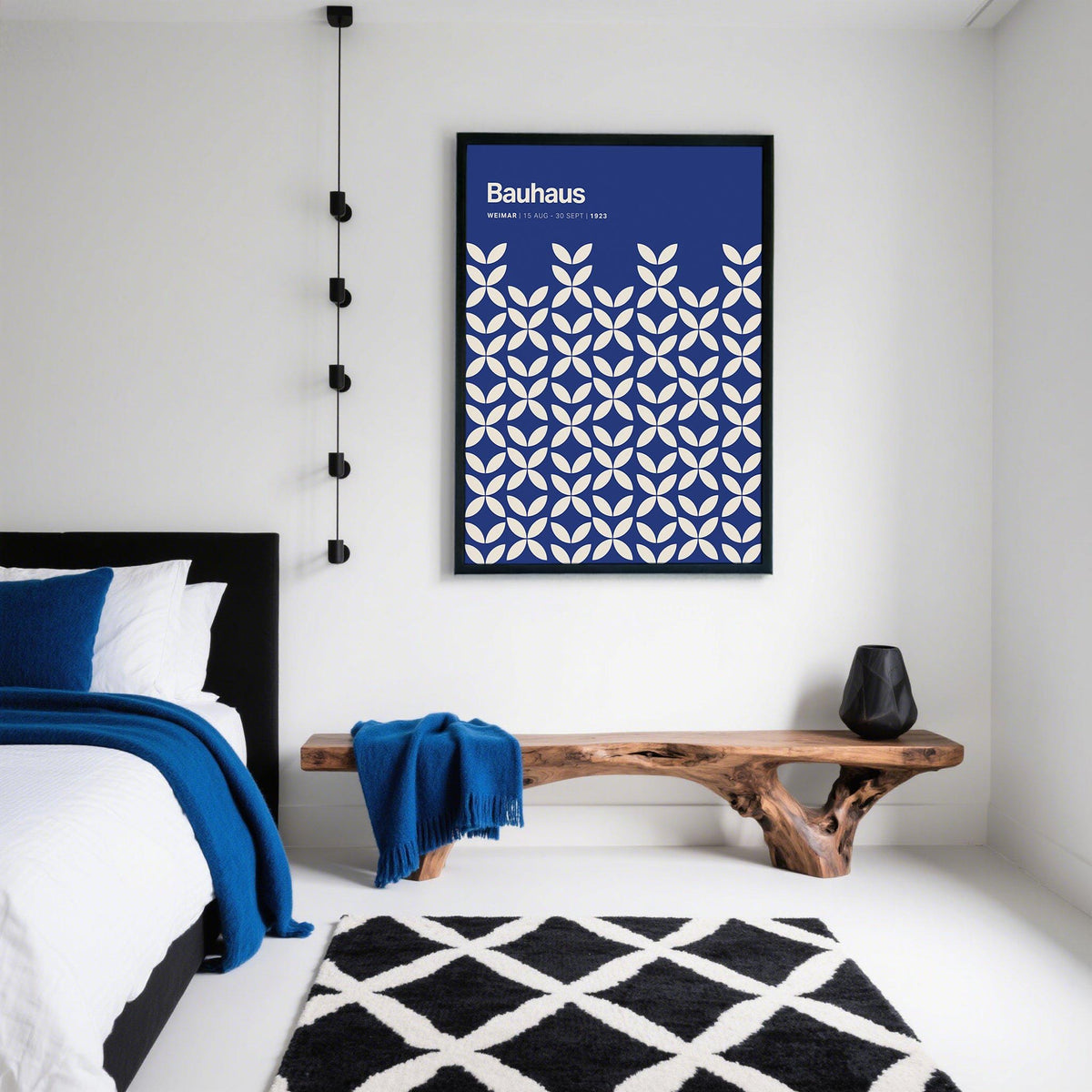 Blue Modern Wall Art with white petal shapes in a black frame on a white wall above a wooden bench