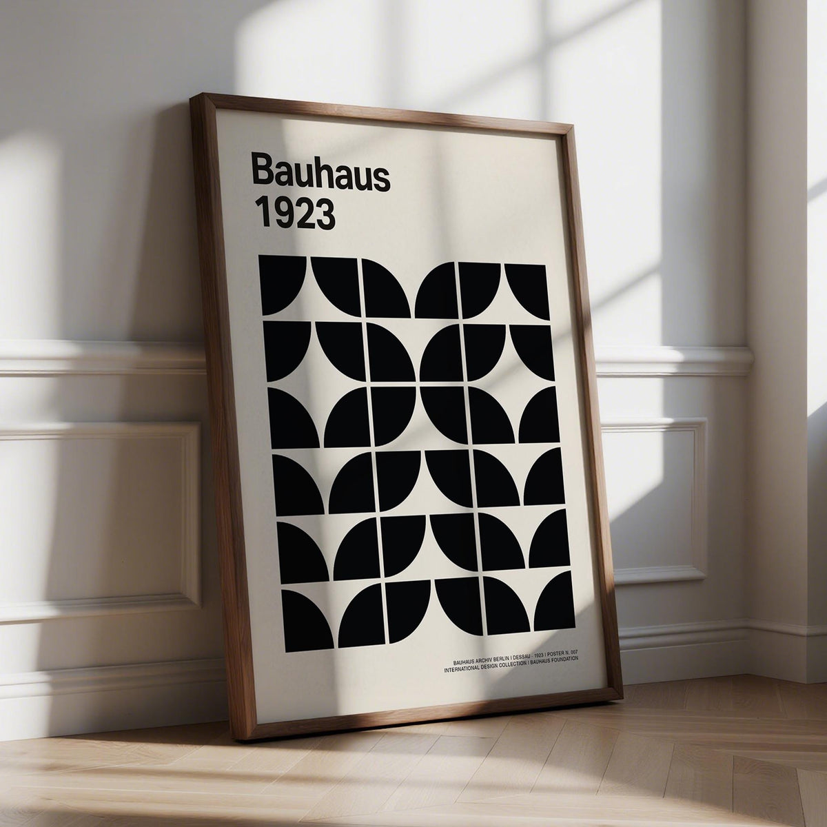 Print leaning on floor with Bauhaus geometric pattern in black and cream lit by window shadows