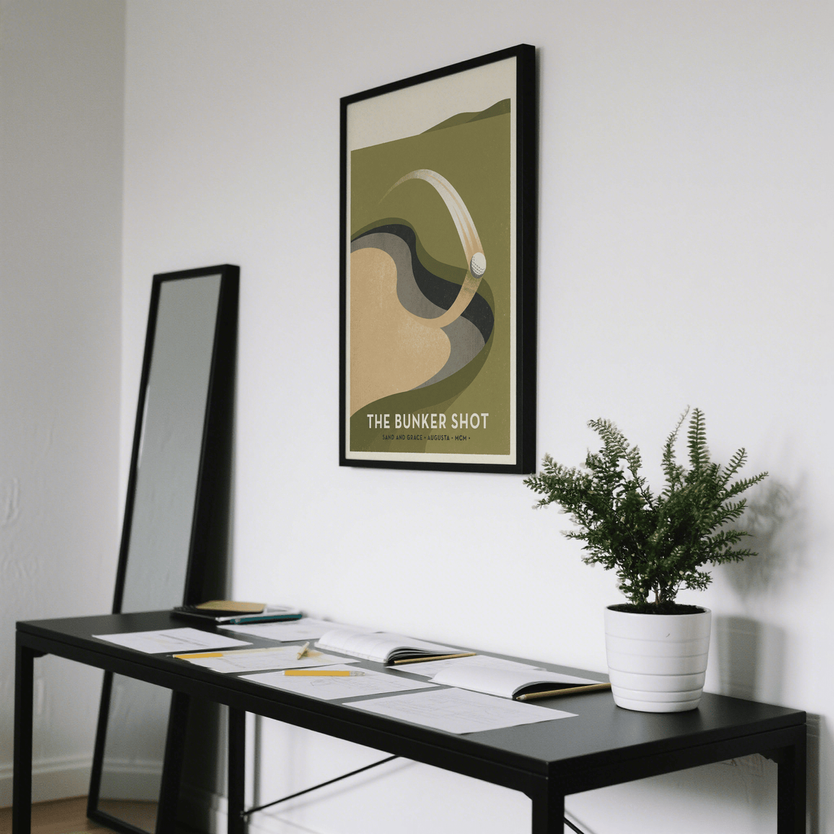 Golf Bunker Art Print framed in black on a white wall above a black table with a green plant