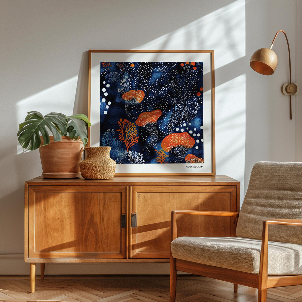 Abstract Floral Art print with orange mushrooms and blue watercolour leaning on a wooden sideboard with a plant and lamp
