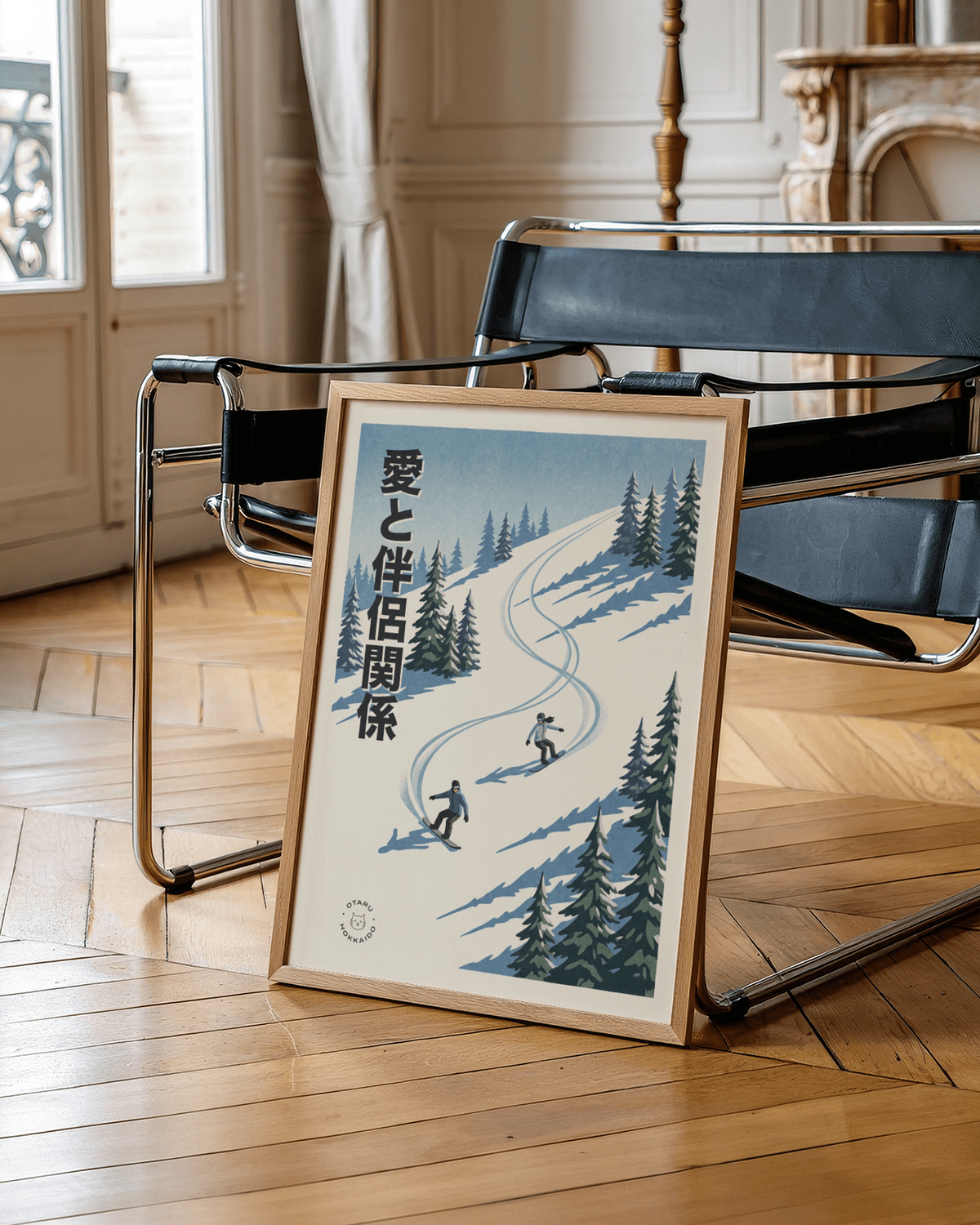 Snowboarding wall art leaning on a black chair with wooden floor and bright windows