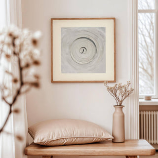 Surrealism Posters framed print of concentric sand circles in soft greys above wooden table with beige cushion and vase