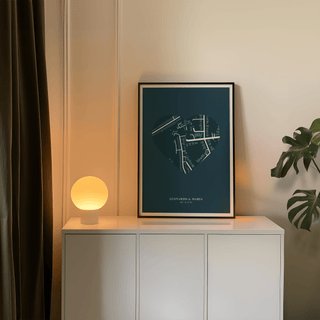 Love Map Poster print leaning on a white cabinet with a lit round lamp and green plant nearby