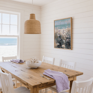 Wildflower Beach Print hanging on white shiplap wall above wooden dining table with purple napkins