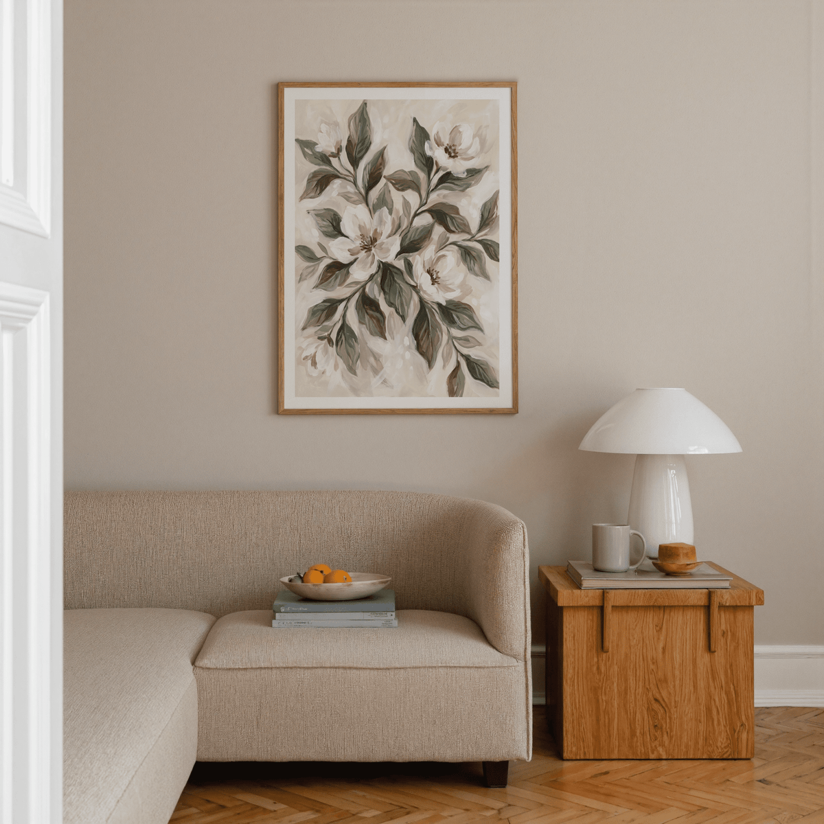 Magnolia wall decor of magnolia flowers in watercolour style above a beige sofa with a wooden side table and lamp