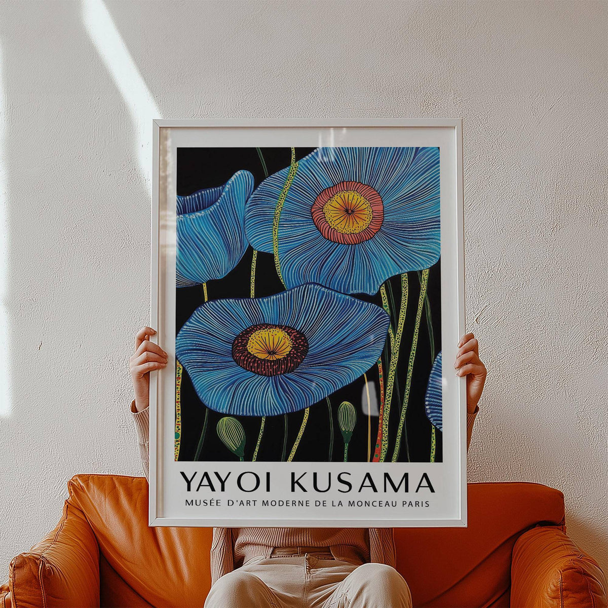 Framed Big Flower Wall Art held in hands showing blue poppy flowers with yellow centres and black background
