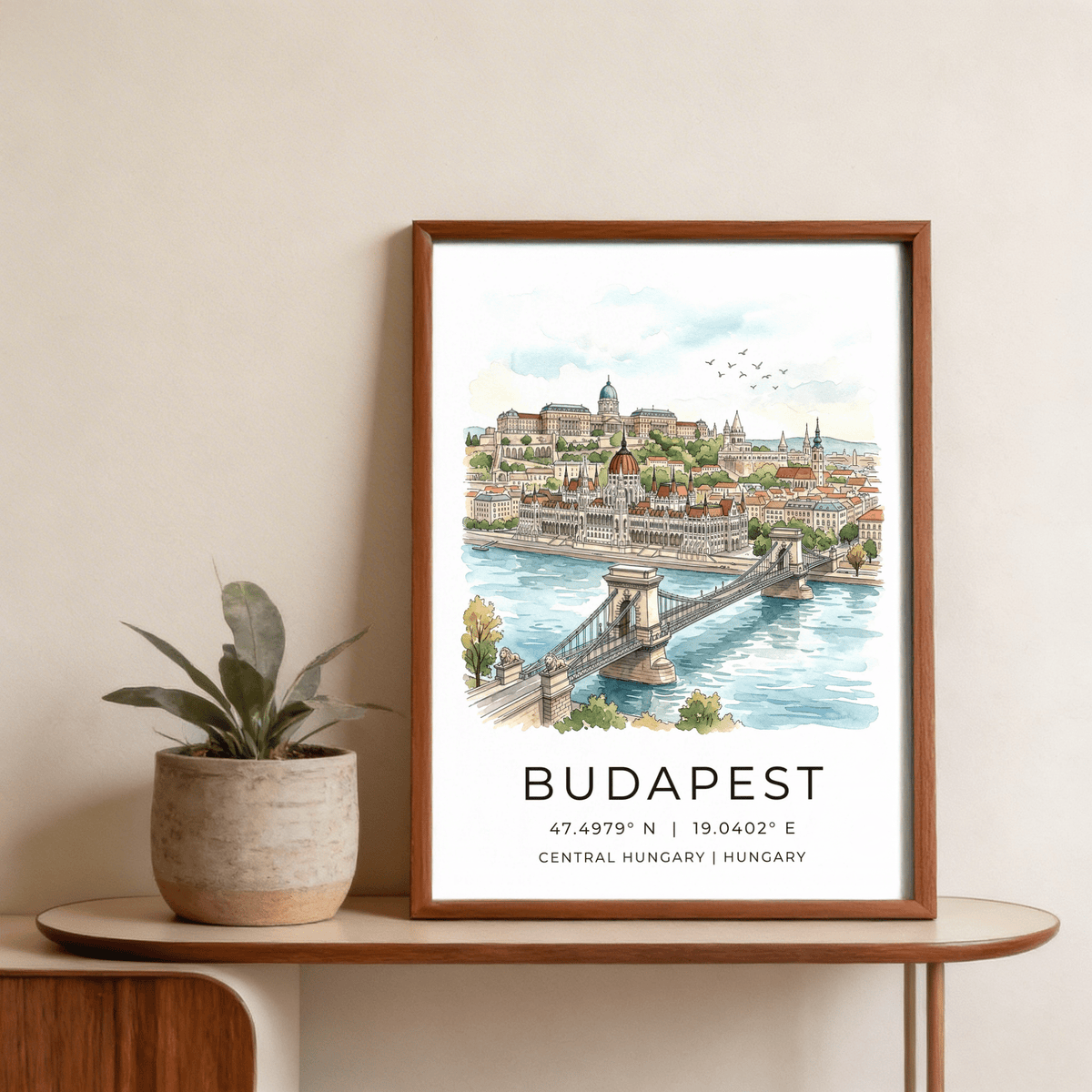 Framed Budapest Cityscape wall art watercolour illustration with Chain Bridge next to a potted plant