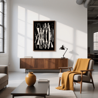 Abstract black and white wall art of torn stripes above wooden sideboard with lamp