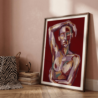 Contemporary Figure Art print leaning on a floor with a stack of books and a small sculpture nearby