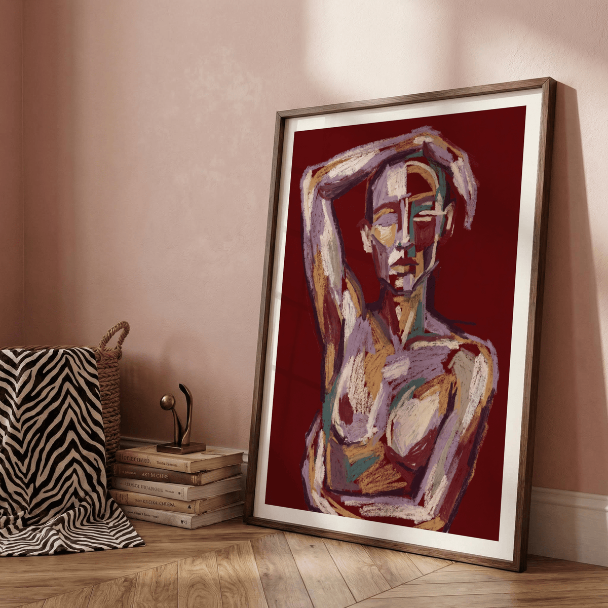 Contemporary Figure Art print leaning on a floor with a stack of books and a small sculpture nearby