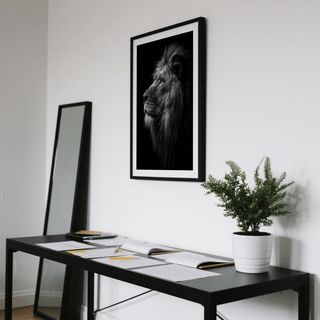 Lion wall art showing a photographic profile of a lion in black and white above a desk with papers and a plant