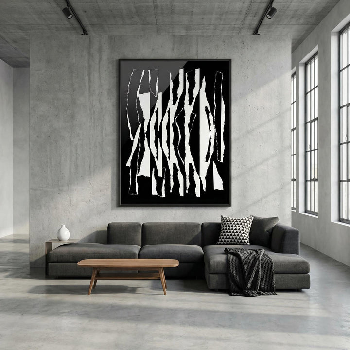 Abstract Black And White wall art with torn stripes in a large frame above a dark grey sofa with a patterned cushion