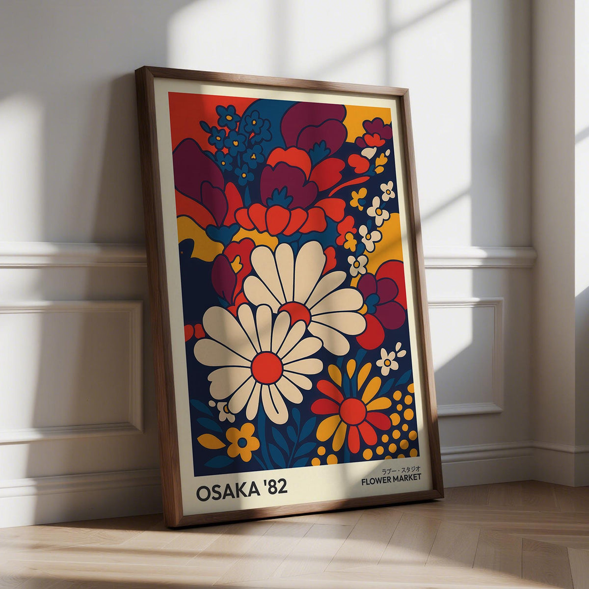 Retro wall art print with daisy flowers in red blue and cream leaning against a white wall in natural light