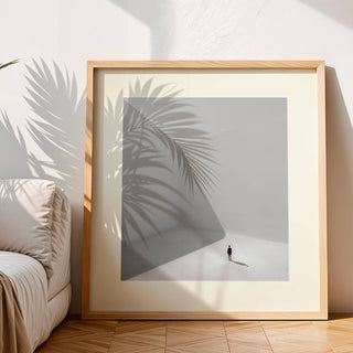 Framed Square Art Prints leaning on floor with shadow of plant leaves across the minimalist photographic print