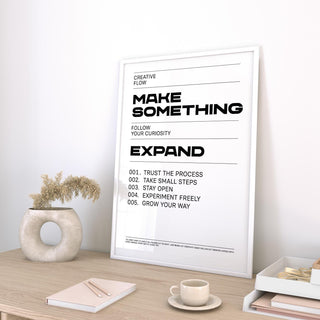 Quotes for Room Wall print leaning on a desk with a ceramic vase and books nearby