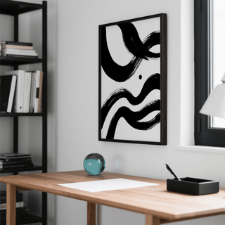 Black and white paintings abstract hanging above a wooden desk with a glass paperweight in a bright room