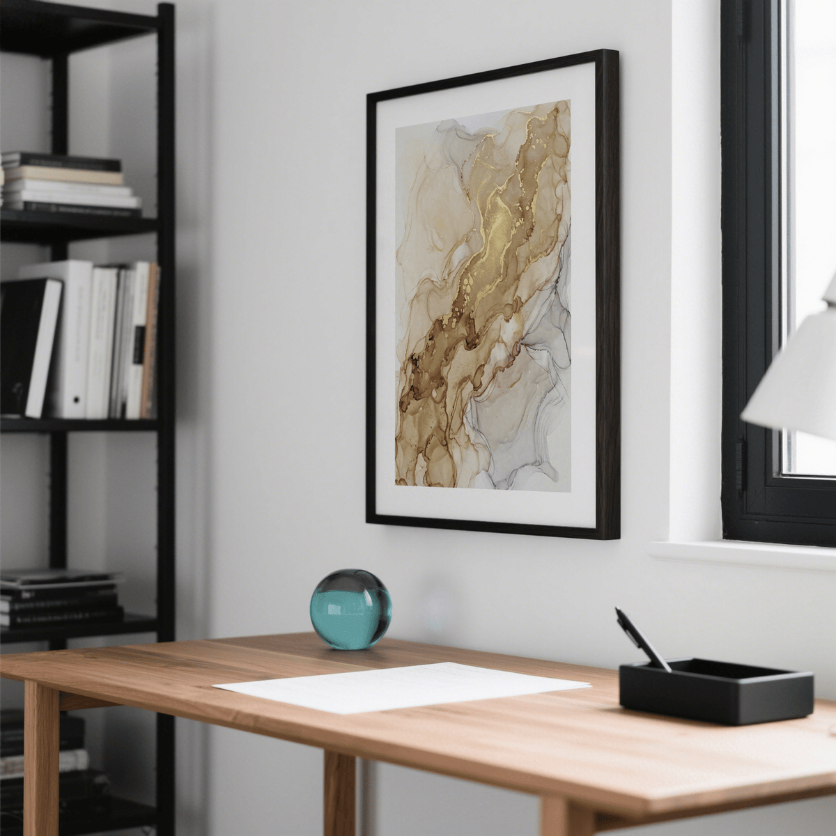 Abstract Gold Art Print on a wall with gold and beige swirls above a wooden desk with a glass paperweight