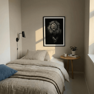Print on a wall of black lion art print with a realistic photographic style above a beige bed and wooden side table