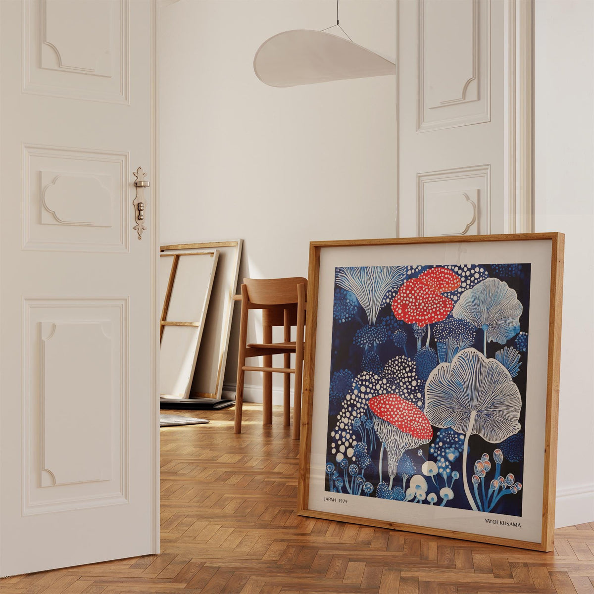 Mushroom Poster leaning on wooden floor near an open white door with a wooden chair in the background