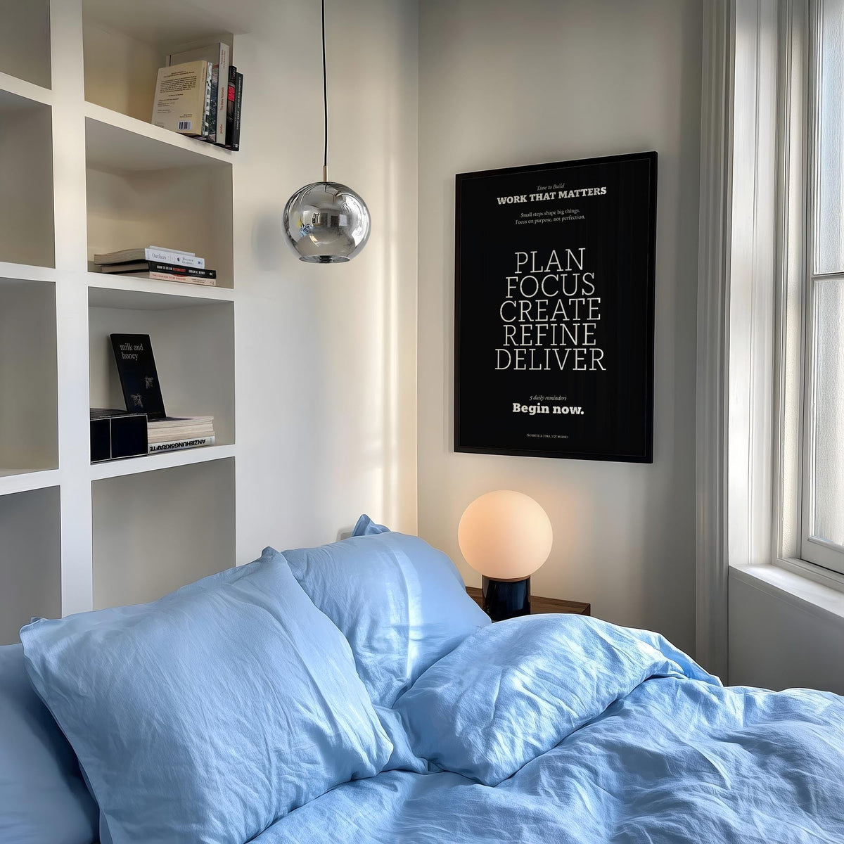 Inspiring wall decor with motivational text in black and white above a bedside lamp in a bedroom
