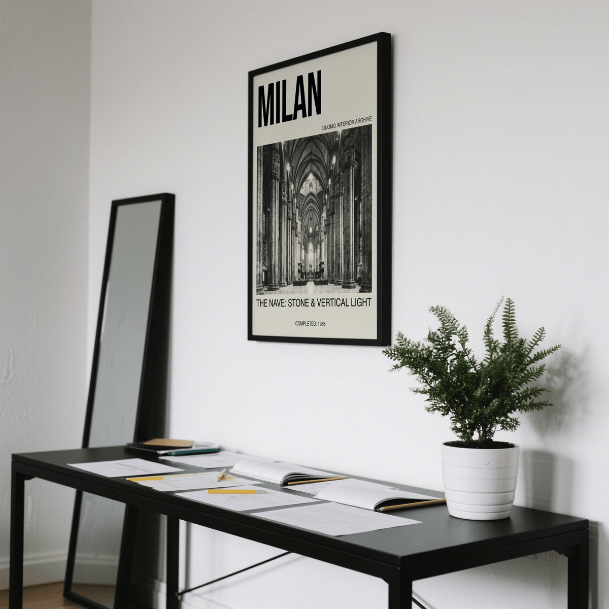 Print on a wall in a room showing Milan Architecture Art Print with black frame and green plant on a black table