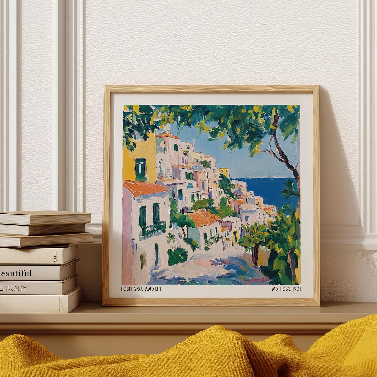 Framed Positano Art print of an italian coastal village in watercolour on a shelf with books