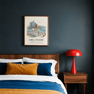 Print on a wall in a bedroom showing Abu Dhabi Art Print with blue and tan tones and a red lamp nearby