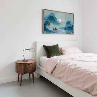 Serene Nature Poster print of a fisherman on a river in blue tones above a bedside table in a bedroom