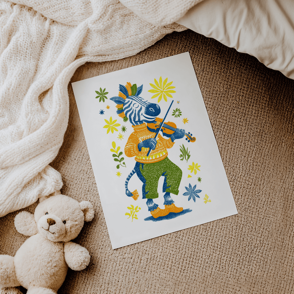 Zebra Playing Violin Poster laid on carpet with teddy bear and blanket nearby in soft colours