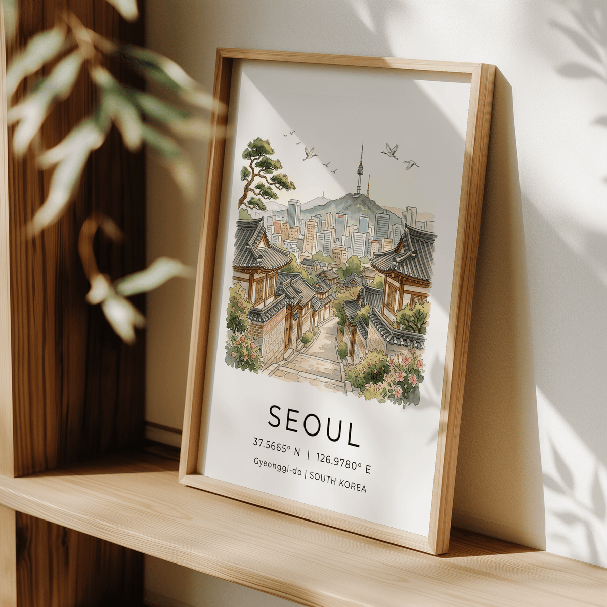 Seoul Landscape Art Print leaning on a shelf with sunlight and leafy shadows