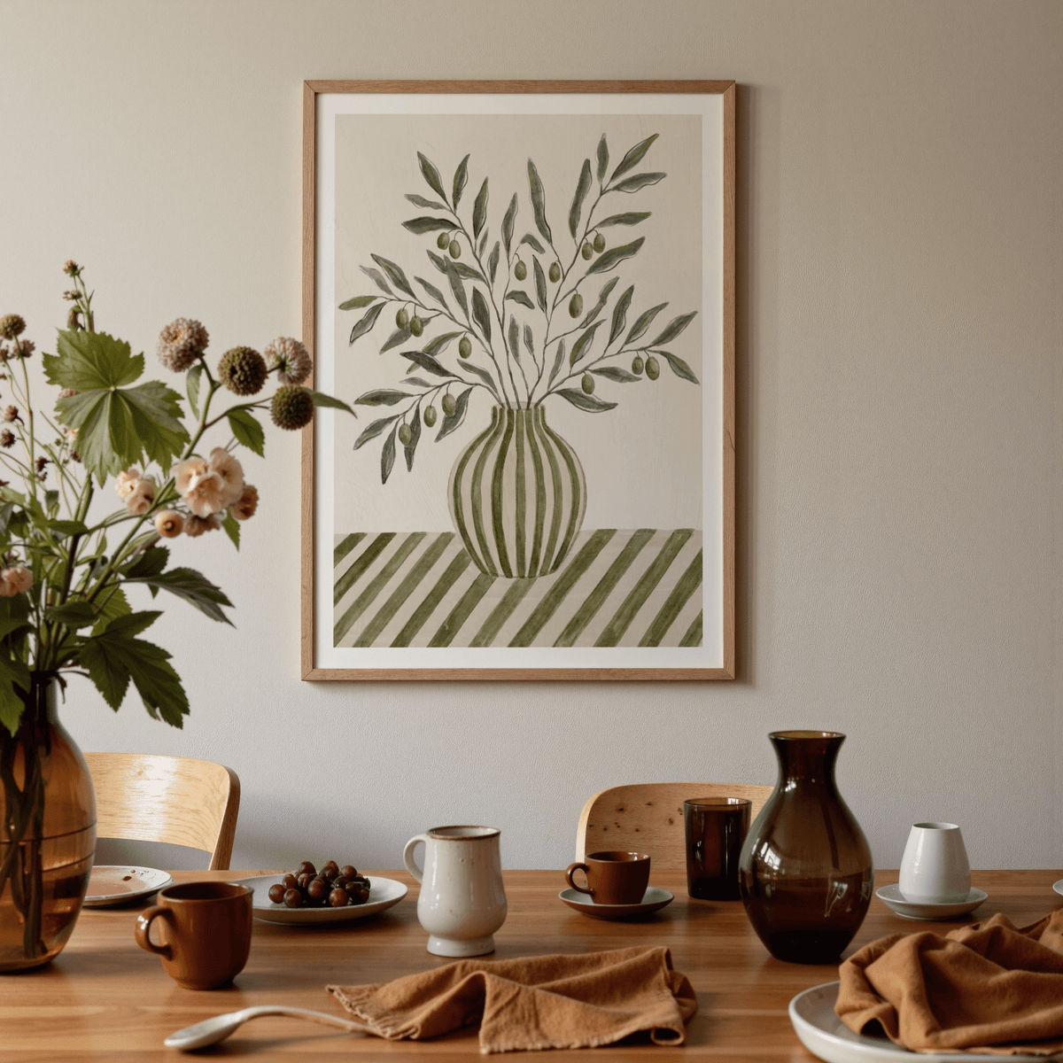 Olive Branch Art print on a wall in a dining room with brown tableware and a vase with flowers