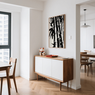 Bamboo black and white print on a wall above a sideboard with a cat ornament and red tray in a dining room
