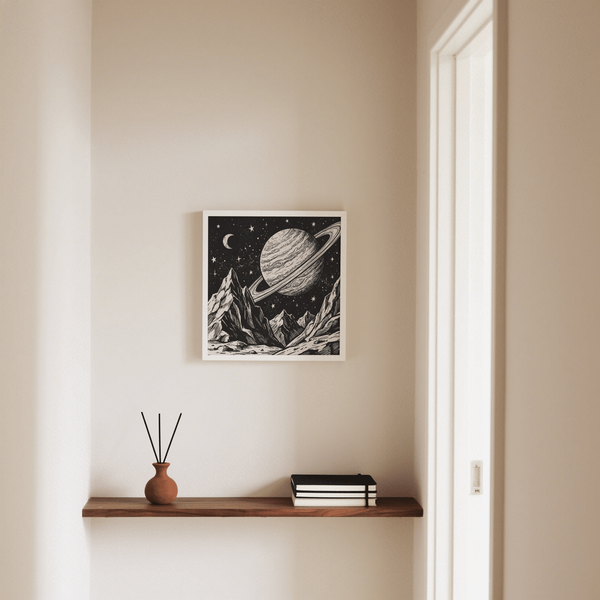 Print on a wall of a mountain space poster in black and white above a wooden shelf with a brown vase and reed diffuser