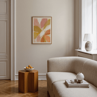 Floral Watercolor Art Print on a beige wall above a wooden side table with a bowl of fruit in a living room