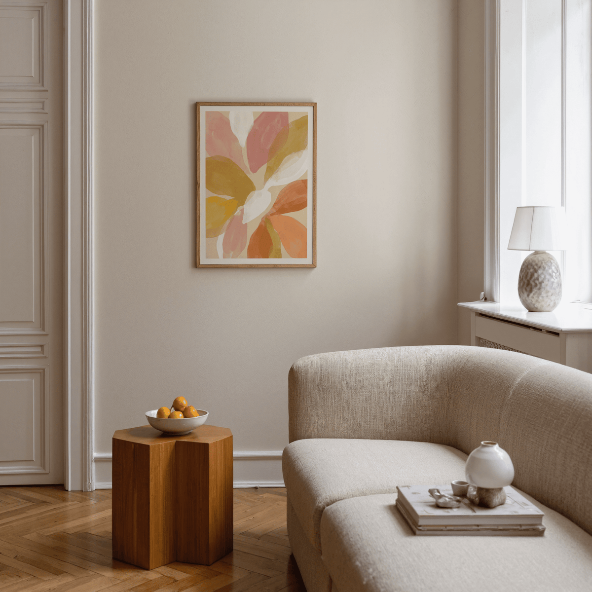 Floral Watercolor Art Print on a beige wall above a wooden side table with a bowl of fruit in a living room