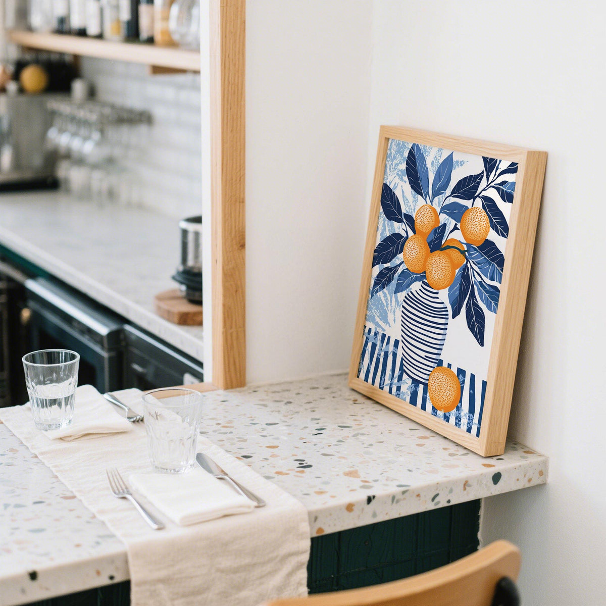 Orange Blue wall art leaning on a terrazzo kitchen counter with a glass of water nearby